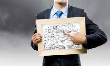 Business strategy. Close up of businessman holding frame with business sketches