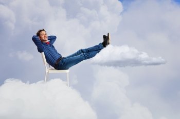 Relaxed guy. Young man sitting in chair with legs up and relaxing