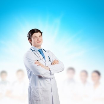 Confident doctor. Image of happy confident doctor in uniform with colleagues at background