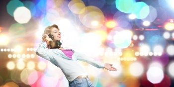 Music is my life!. Young woman wearing headphones against bokeh background