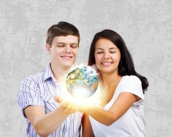 Young family. Young happy couple holding earth planet in palms. Elements of this image are furnished by NASA