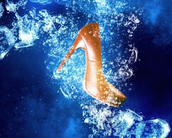 Shoes under water. Heeled shoe sinking in clear blue water