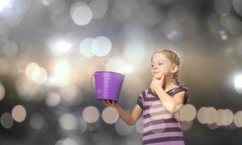 Colorful childhood!. Cute girl with bucket against bokeh background