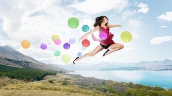 Let’s celebrate. Young cheerful lady in red dress jumping high