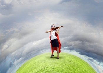 Feel yourself a hero!. Young woman in super hero costume playing violin