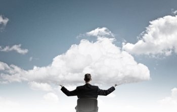 Eco or cloud computing. Back view of businessman in chair holding white cloud 