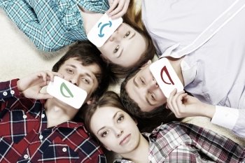 Let’s be friends. Group of young smiling people lying on floor in circle with phone symbols