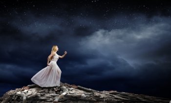Woman in darkness. Young woman in white dress running in darkness