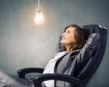 Lady boss. Young confident businesswoman sitting in chair with legs up