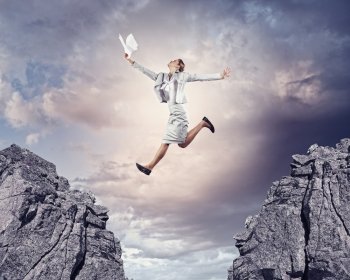 Young businesswoman jumping. Image of young businesswoman jumping over gap