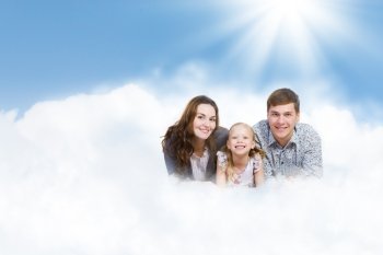 Young family. Happy family of three lying on white cloud