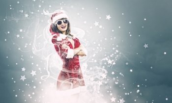Santa girl. Young attractive woman in santa suit and sunglasses