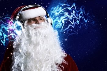 Happy New Year. Santa Claus wearing headphones and enjoying music