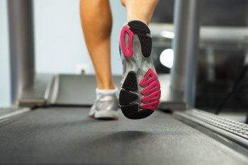 Running on treadmill. Image of female foot running on treadmill