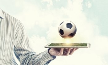 Online game. Tablet pc in male hand and soccer ball on screen
