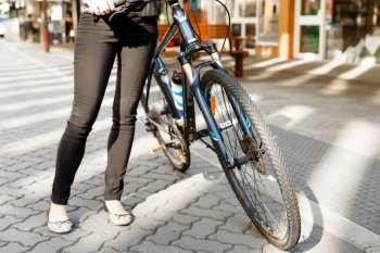 Biking in city. Legs of woman riding bike inn city