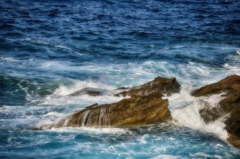 foam  waves splash at stones on shore sea