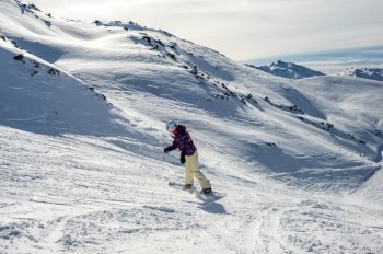 Snowboarder riding at French Alps mountain slopes. Meribel, France