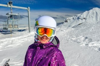 Young woman in ski goggles outdoors with French Alps covered with snow at background. Meribel, France