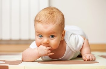Four months old baby crawling on floor
