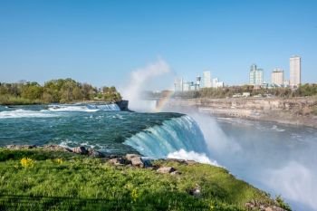 American side of Niagara Falls waterfall with rainbow, view of Canadian side from New York state, USA