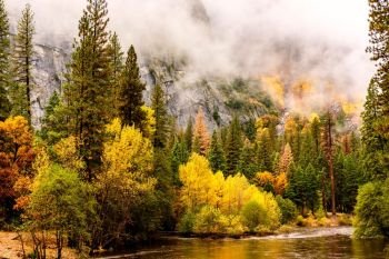 Yosemite National Park Valley and Merced River at autumn. Low clouds lay in the valley. California, USA.