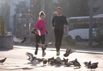 healthy young  couple jogging in the city  at early morning with sunrise in background