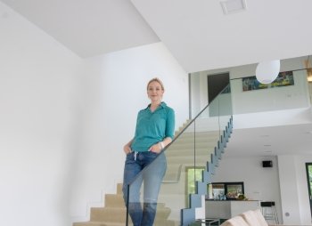 portrait of a young beautiful woman on the stairs in her luxurious home