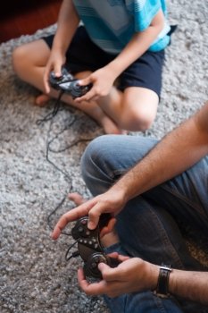 Happy family. Father, mother and children playing a video game Father and son playing video games together on the floor