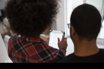 Rear view of young african american couple using tablet at home