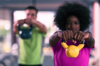 healthy couple  workout with weights lifting  dumbbels at  crossfit gym african  american woman with afro hairstyle