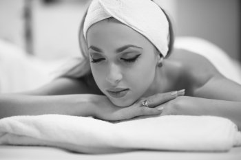 Relaxed young beautiful  woman laying on massage table