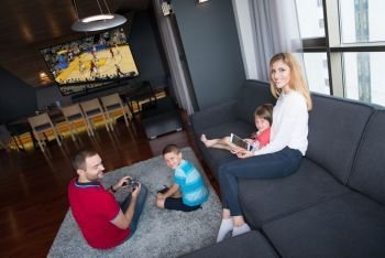Happy family. Father, mother and children playing a basketball video game Father and son playing video games together on the floor