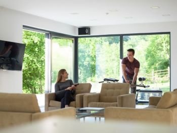 Young couple relaxing at luxurious home woman using tablet computers while man preparing  for exercise