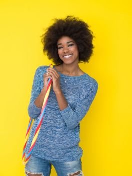portrait of a beautiful friendly African American woman with a curly afro hairstyle and lovely smile isolated on a Yellow background