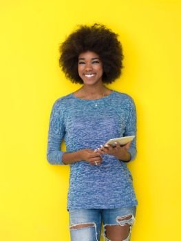 Young Happy African American Woman Using Digital Tablet  Isolated on a yellow background