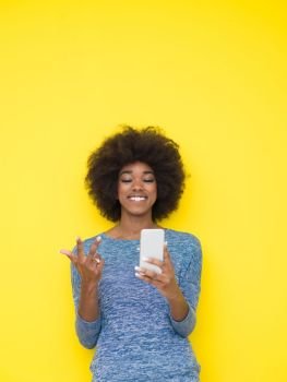 Young Happy African American Woman Using mobile phone  Isolated on a yellow background