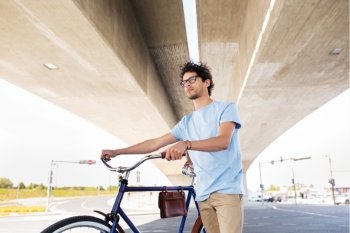 people, style, leisure and lifestyle - hipster man with fixed gear bike under city bridge