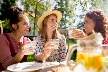 friendship, holidays, celebration, people and food concept - happy women or friends having party at summer garden