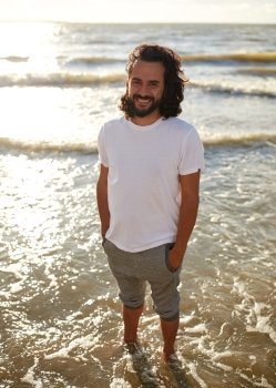 people concept - happy smiling man in white t-shirt on beach over sea. happy man in white t-shirt on beach over sea