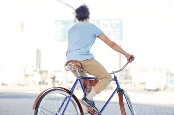 people, style and lifestyle - hipster man riding fixed gear bike on city street
