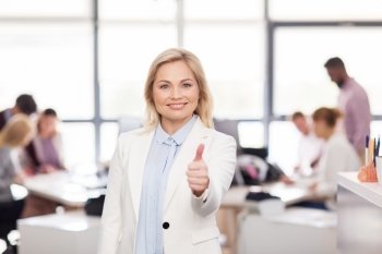 business, gesture, success and people concept - happy businesswoman showing thumbs up at office