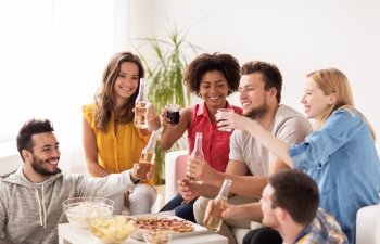 friendship, holidays, fast food and celebration concept - happy friends with drinks and snacks having party at home