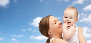 family, motherhood, parenting, people and child care concept - happy mother holding adorable baby over blue sky background