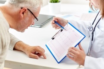 medicine, old age, healthcare, cardiology and people concept - senior man and doctor with cardiogram on clipboard meeting in medical office at hospital