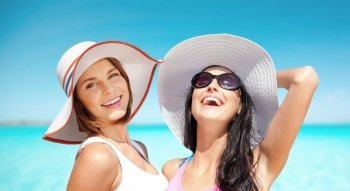 summer holidays, travel, people and vacation concept - happy young women in hats over over exotic tropical beach background