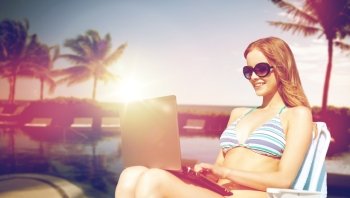summer holidays, vacation, technology, people and internet - happy young woman in shades with laptop computer on beach