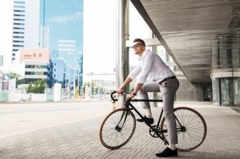 lifestyle, transport and people concept - young man with bicycle and headphones on city street