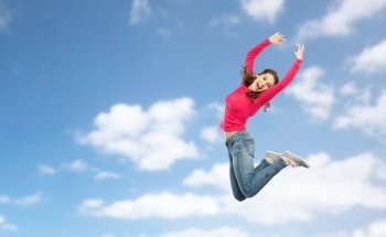 happiness, freedom, motion and people concept - happy young woman jumping or dancing in air over blue sky and clouds background