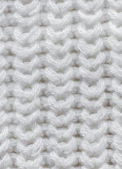 handicraft, knitwear and needlework concept - close up of knitted item